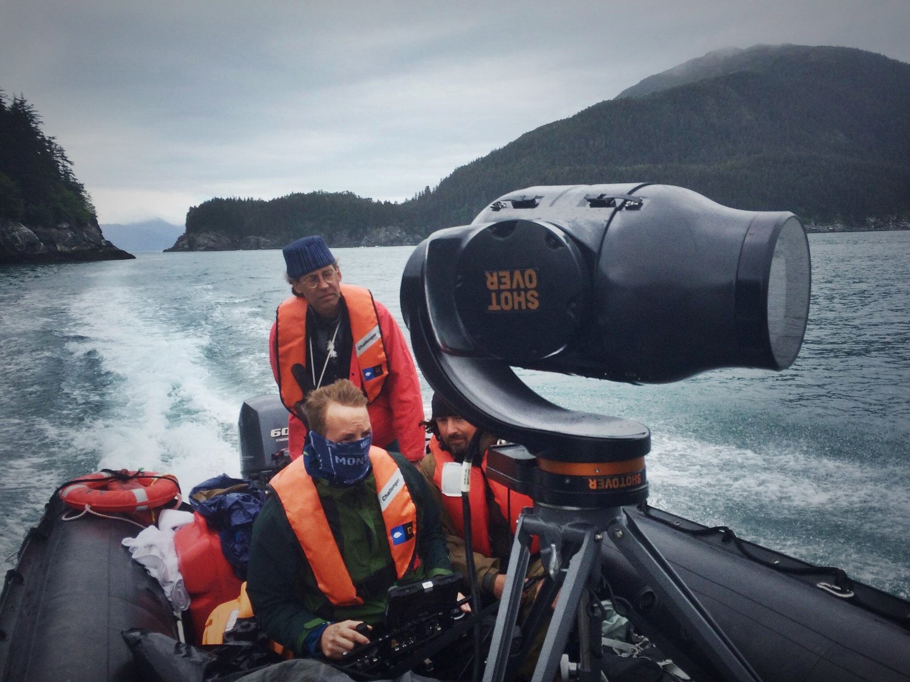 A documentary crew and mounted cinema camera on a small boat